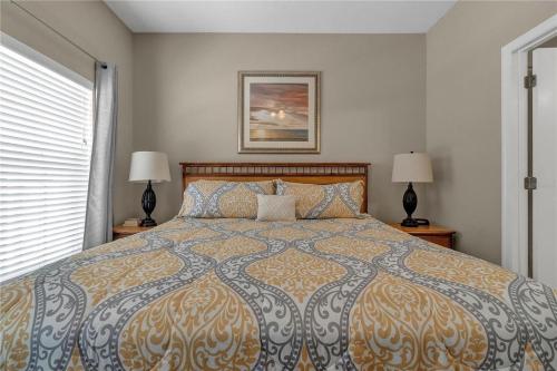 a bedroom with a large bed with two lamps at Enjoy my cozy house next to Disney in Kissimmee