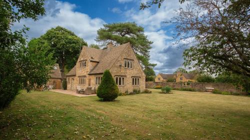 a large stone house with a yard at Arlington House in Lower Slaughter