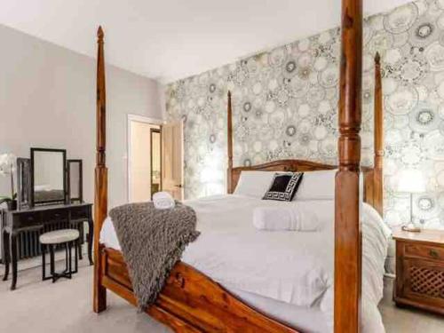 a bedroom with a wooden bed and a television at Chapter One - Ashbourne in Mapleton