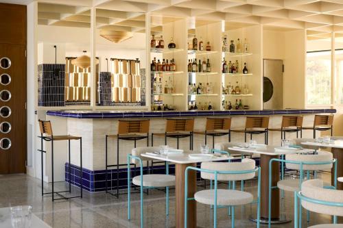 a restaurant with tables and chairs and a bar at Ace Hotel & Swim Club Athens in Athens