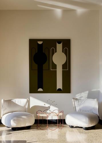 a room with two chairs and a painting on the wall at Ace Hotel & Swim Club Athens in Athens
