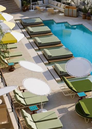 a group of chairs and tables next to a pool at Ace Hotel & Swim Club Athens in Athens
