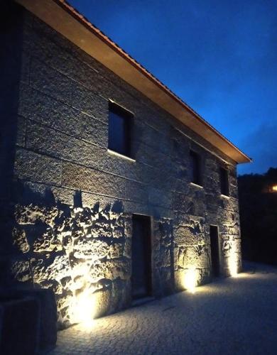 a stone building with lights on the side of it at Casa do Reguengo, Freigil in Resende