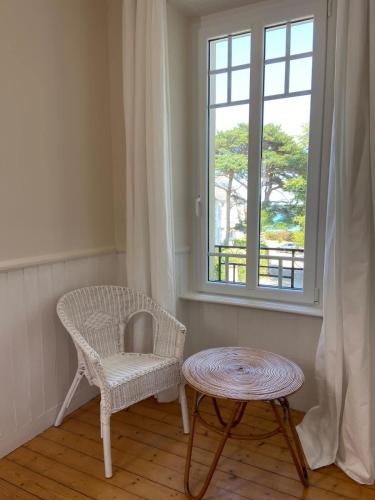 a chair and a table in a room with a window at CARANTEC FAMILY HOME WITH GARDEN 6 persons in Carantec