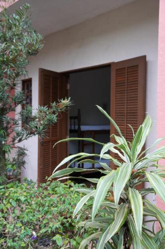 a house with a plant in front of a building at Refúgio do Kairós in Ubatuba