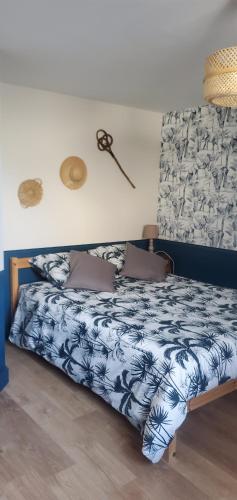 a bedroom with a bed with a blue and white comforter at Le Cabinet-Charmante maison avec terrain in Châtillon-sur-Seine