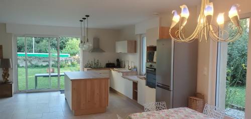 une cuisine avec un lustre suspendu au-dessus d'un comptoir dans l'établissement Le Cabinet-Charmante maison avec terrain, à Châtillon-sur-Seine