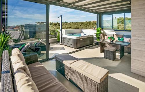 a patio with a hot tub and a table and chairs at 3 Bedroom Awesome Apartment In Kozino in Kožino