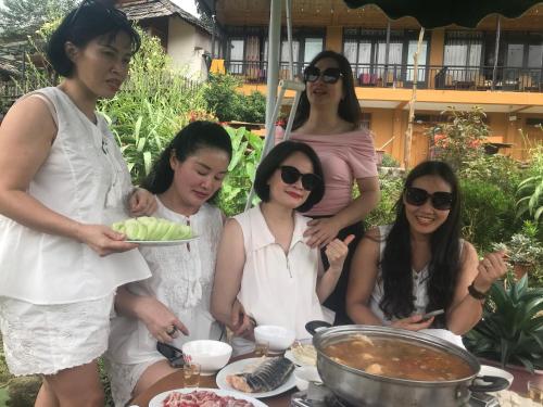 a group of women standing around a table with food at Sau Meo Mountain View in Sa Pa