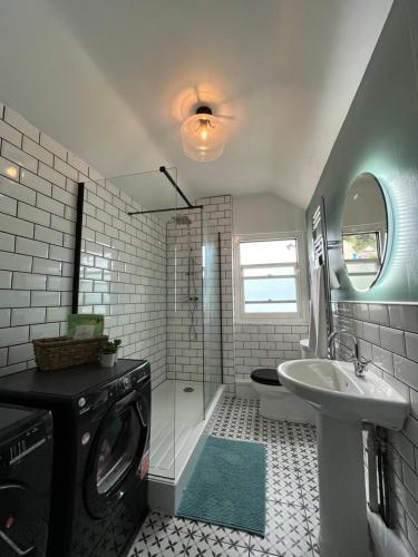 ein Badezimmer mit Waschmaschine und Waschbecken in der Unterkunft Oysterman's Cottage in The Mumbles
