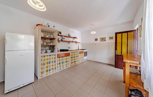 a kitchen with a refrigerator and a tiled floor at Gorgeous Home In Zrnovo in Žrnovo
