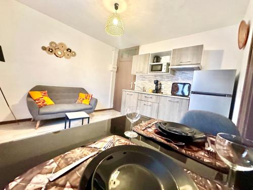 une cuisine et un salon avec un canapé et une table dans l'établissement Le Safari, central et cosy, à Limoges