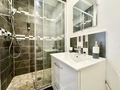 une salle de bain avec un lavabo et une douche dans l'établissement Le Safari, central et cosy, à Limoges