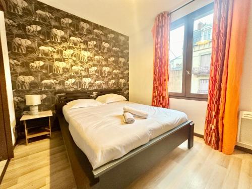 une chambre avec un lit avec un mur avec des moutons dessus dans l'établissement Le Safari, central et cosy, à Limoges