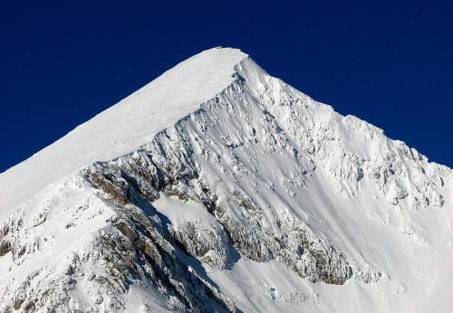 a mountain covered in snow with a blue sky at Guest House Kraljev Hrib in Kamniška Bistrica