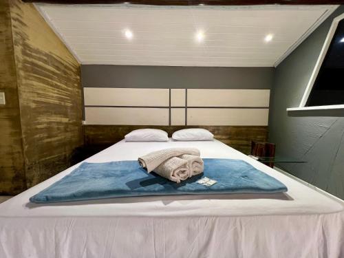 a bed with a blanket and towels on it at Espaço Verano - Suíte Master 2 in Niterói