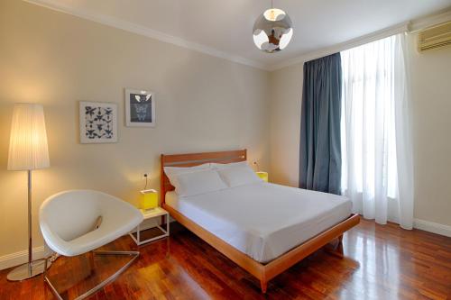 a bedroom with a bed and a chair in it at The Rooms Serviced Apartments Tirana in Tirana