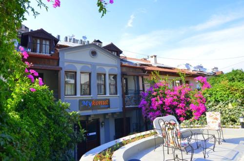 a building with chairs and flowers in front of it at Mykonut Boutique Suites in Fethiye