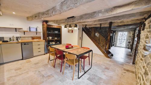 une cuisine avec une table et des chaises dans une pièce dans l'établissement Magnifique Maison Bretonne - Gîte Ar Baradoz, à Kergrist