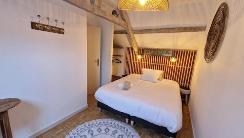 une chambre avec un lit blanc dans une pièce dans l'établissement Magnifique Maison Bretonne - Gîte Ar Baradoz, à Kergrist