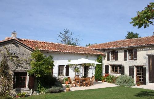 Elle offre une vue sur l'extérieur d'une maison blanche dotée d'une terrasse. dans l'établissement La Cotte Remote house for family getaway in Périgord, à Nanteuil-Auriac-de-Bourzac