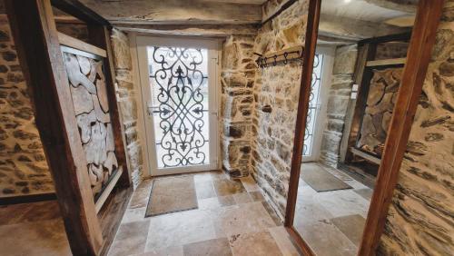 - une porte dans une pièce dotée d'un mur en pierre dans l'établissement Magnifique Maison Bretonne - Gîte Ar Baradoz, à Kergrist