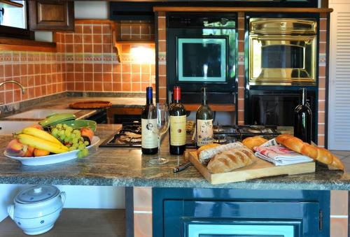 a kitchen with a counter with bread and wine bottles at Villa Montermoli Tuskany in Santa Maria