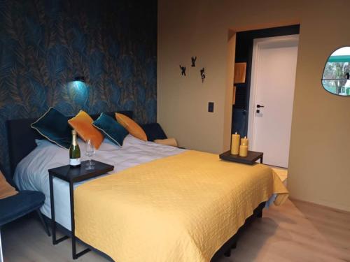 a bedroom with a large bed with a yellow blanket at ' t Geel Huizeken - B&B - koffiehuis in Denderleeuw
