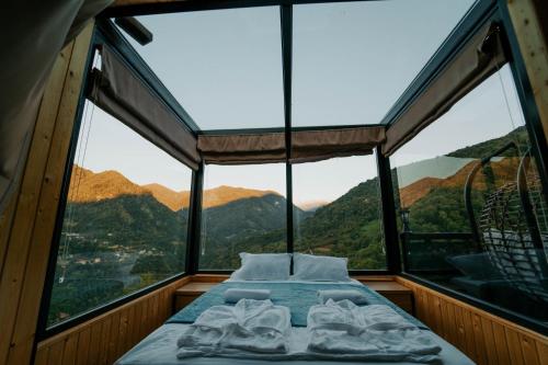 a bed in a room with a view of mountains at Machakhela view in Batumi