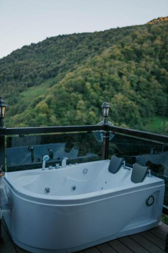 a white bath tub sitting on a deck with a mountain at Machakhela view in Batumi