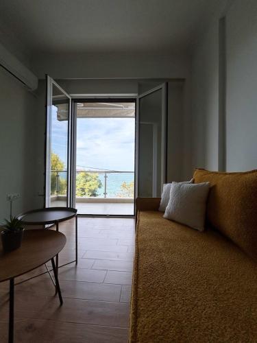 ein Wohnzimmer mit Couch und großem Fenster in der Unterkunft OpenSea #2 in Chalkida