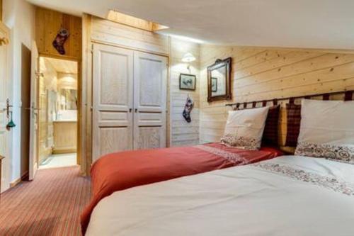 une chambre avec deux lits dans une pièce dans l'établissement Chalet Ancolie 2e Appartement cosy dans un chalet, à Val dʼIsère