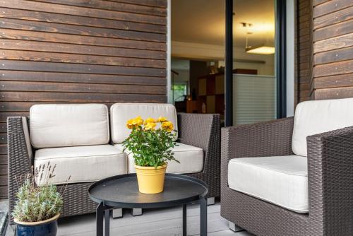 a patio with two chairs and a table with flowers at Ferienwohnung Refugium Nest in Sigmaringen
