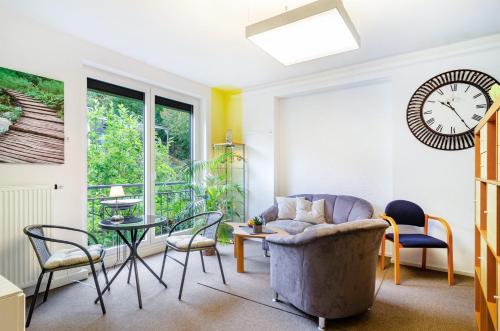 a living room with a chair and a clock on the wall at Ferienwohnung Refugium Nest in Sigmaringen