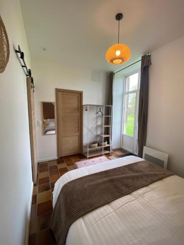 une chambre avec un grand lit et une fenêtre dans l'établissement L'Origami - Domaine de la Houblette, à Challans