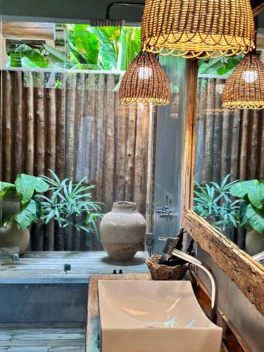 a bathroom with a sink and a window with plants at Soleluna Casa Pousada in Trancoso