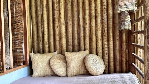 a bed with two pillows in a room with a wall at Soleluna Casa Pousada in Trancoso
