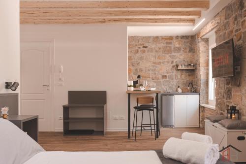 ムッジャにあるCALLE DE BERNARDIS 1 l BB APARTMENTS TRIESTEのレンガの壁のリビングルーム、キッチンが備わります。