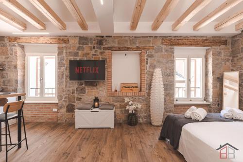 ムッジャにあるCALLE DE BERNARDIS 1 l BB APARTMENTS TRIESTEのベッドが2つとレンガの壁がある部屋