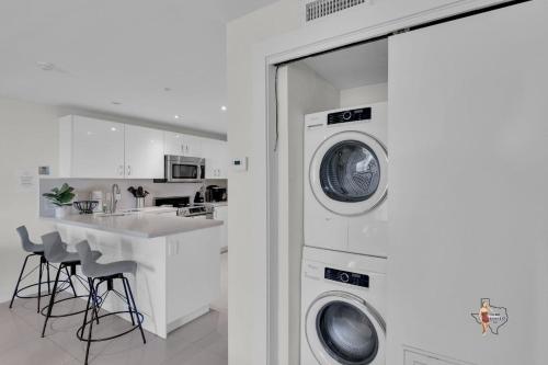 a kitchen with a washer and dryer next to a counter at Bahia Mar Solare Beachfront Resort Condos with Two Pools in South Padre Island