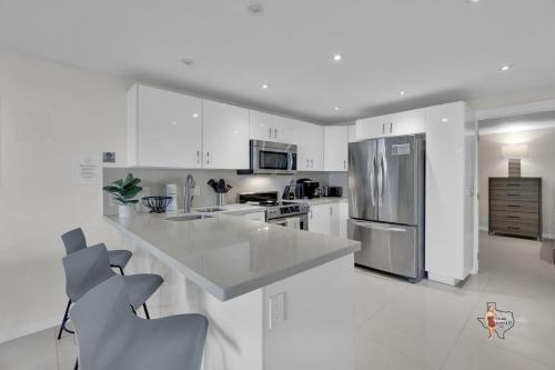 a kitchen with white cabinets and a stainless steel refrigerator at Bahia Mar Solare Beachfront Resort Condos with Two Pools in South Padre Island