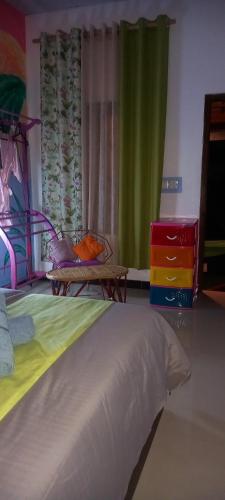 a bedroom with a bed and a dresser and a window at Elena Garden Resort and Restaurant in Trincomalee