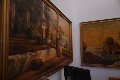 a painting hanging on a wall next to a laptop at ApartHotel Antica Repubblica in Amalfi center at 100mt from the sea in Amalfi