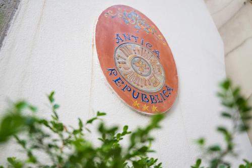 a plaque on the side of a building with a plant at ApartHotel Antica Repubblica in Amalfi center at 100mt from the sea in Amalfi
