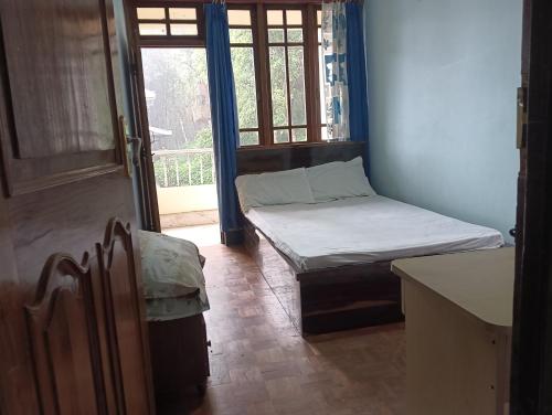 a small room with a bed and a window at Ronglyang Lotus Villa in Tādong