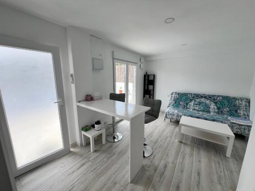 a white living room with a table and a couch at Estudio nuevo zen in Calafell