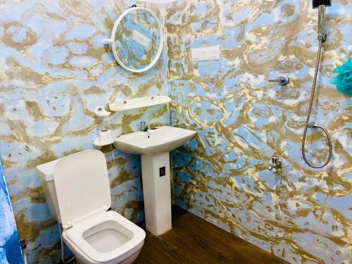 a bathroom with a toilet and a sink and a shower at Milano Grand in Matara