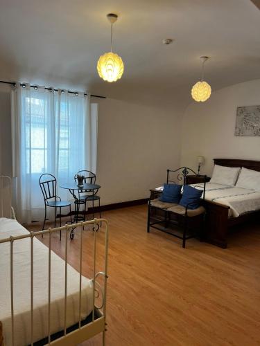 a bedroom with a bed and a table and chairs at Avis Guesthouse in Évora