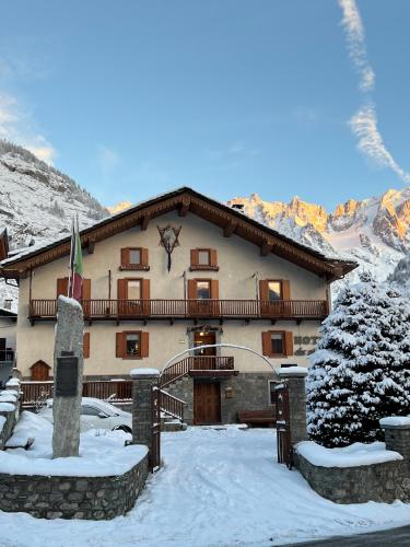 a large building with snow on the ground at Hotel Des Glaciers in Courmayeur