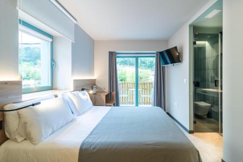 a bedroom with a large bed and a bathroom at Casa rural Goiko Errota landetxea in Arrasate - Mondragon